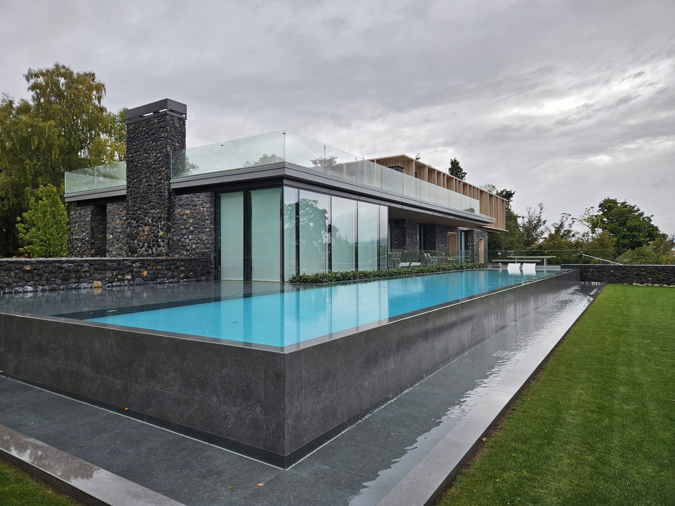 A modern deck pool with glass fence