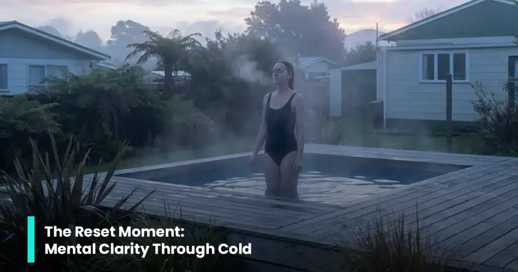 Woman standing in a backyard plunge pool at dusk, practising calm breathing for a cold dip reset.